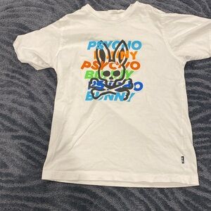 BOYS PSYCHO BUNNY WHITE T SHRT WITH LOGO AND “PSYCHO BUNNY” ON FRONT